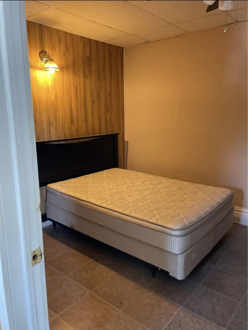 Small bedroom with mattress and wood accent