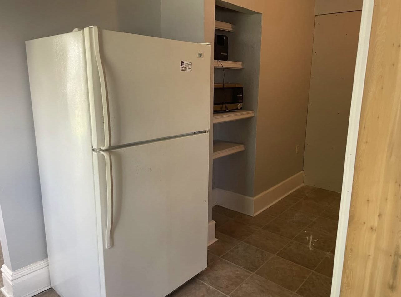 White refrigerator tucked in pantry nook