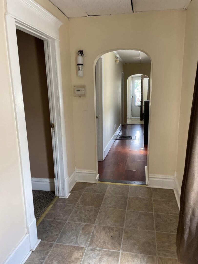 Hallway with arched doorway and tile floor