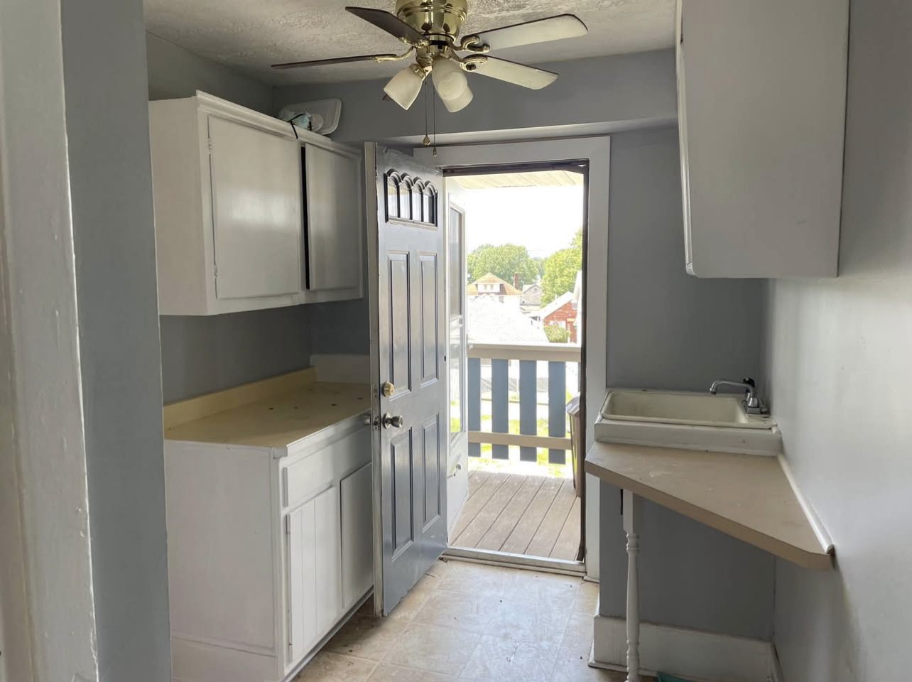 Small kitchenette with open door to balcony